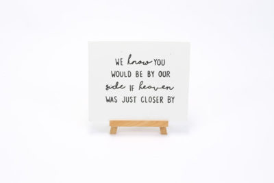 White wooden sign- "We know you would be by our side if heaven was closer by"