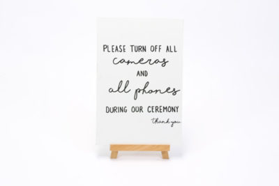 White wooden sign- "Please Turn off all cameras and all phones- Thank you"