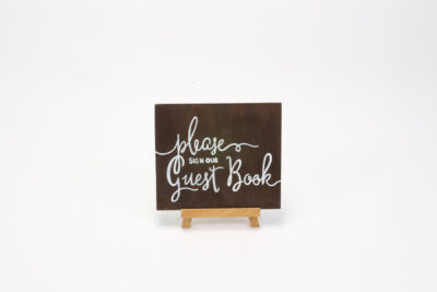 Dark wooden sign- "Please sign our guest book"